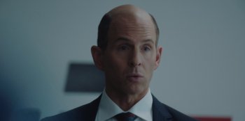 Movie still from “BlackBerry” (2023), directed by Matt Johnson – A man in a suit and tie looking at the camera; Close Up shot, Over the shoulder angle