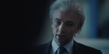 Movie still from “BlackBerry” (2023), directed by Matt Johnson – A person wearing a suit and tie; Close Up shot, Over the shoulder angle