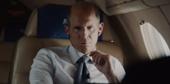 Movie still from “BlackBerry” (2023), directed by Matt Johnson – A man sitting in the back seat of a car wearing a tie; Close Up shot, Over the shoulder angle