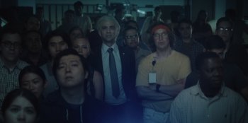 Movie still from “BlackBerry” (2023), directed by Matt Johnson – A group of people standing in front of a crowd; Medium shot, Low angle