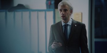 Movie still from “BlackBerry” (2023), directed by Matt Johnson – A man in a suit and tie holding a cell phone; Close Up shot, Over the shoulder angle