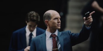 Movie still from “BlackBerry” (2023), directed by Matt Johnson – A man in a blue suit and a red tie; Medium shot, Low angle
