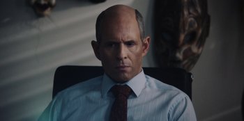 Movie still from “BlackBerry” (2023), directed by Matt Johnson – A man with a bald head wearing a tie; Close Up shot, Over the shoulder angle