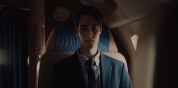Movie still from “BlackBerry” (2023), directed by Matt Johnson – A man in a suit and tie sitting in a car seat; Close Up shot, Low angle