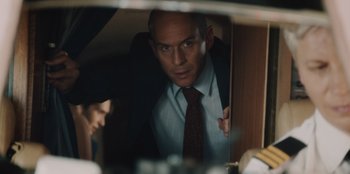 Movie still from “BlackBerry” (2023), directed by Matt Johnson – A man wearing a suit and tie looking into a mirror; Medium shot, Low angle