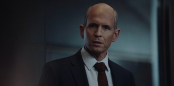 Movie still from “BlackBerry” (2023), directed by Matt Johnson – A man in a black suit and a red tie; Close Up shot, Over the shoulder angle
