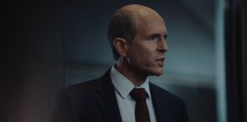 Movie still from “BlackBerry” (2023), directed by Matt Johnson – A man in a black suit and a red tie; Close Up shot, Over the shoulder angle