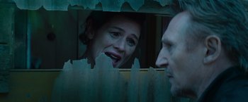 Movie still from “Blacklight” (2022), directed by Mark Williams – A woman looking at a man through a fence; Close Up shot, Low angle