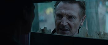 Movie still from “Blacklight” (2022), directed by Mark Williams – A person in a car looking in a mirror; Close Up shot, Over the shoulder angle