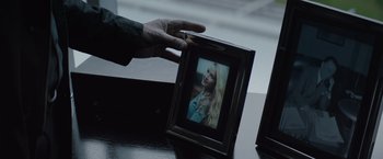 Movie still from “Blacklight” (2022), directed by Mark Williams – A hand is holding a picture of a woman; Extreme Close Up shot, Over the shoulder angle