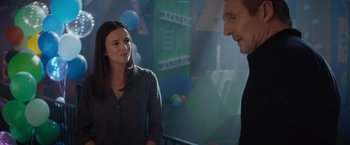 Movie still from “Blacklight” (2022), directed by Mark Williams – A man and a woman are talking in a room; Medium shot, Over the shoulder angle