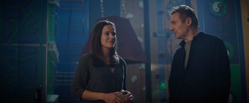 Movie still from “Blacklight” (2022), directed by Mark Williams – A woman standing next to a man in front of a wall; Medium shot, Over the shoulder angle