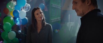 Movie still from “Blacklight” (2022), directed by Mark Williams – A woman standing next to a man in a room; Medium shot, Over the shoulder angle