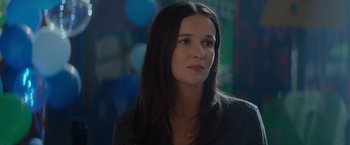 Movie still from “Blacklight” (2022), directed by Mark Williams – A beautiful young lady with long dark brown hair; Close Up shot, Over the shoulder angle