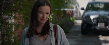 Movie still from “Blacklight” (2022), directed by Mark Williams – A beautiful woman with long dark brown hair wearing a gray shirt; Close Up shot, Over the shoulder angle