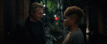 Movie still from “Blacklight” (2022), directed by Mark Williams – A man and a woman are standing next to each other; Close Up shot, Low angle