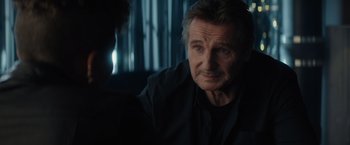 Movie still from “Blacklight” (2022), directed by Mark Williams – An older man sitting in front of a window; Close Up shot, Over the shoulder angle