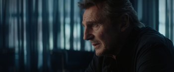 Movie still from “Blacklight” (2022), directed by Mark Williams – A person looking at something; Close Up shot, Over the shoulder angle