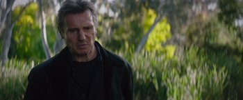 Movie still from “Blacklight” (2022), directed by Mark Williams – A person wearing a black shirt; Close Up shot, Over the shoulder angle