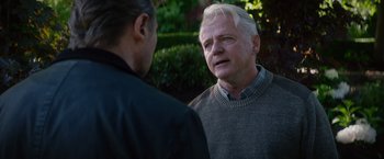 Movie still from “Blacklight” (2022), directed by Mark Williams – A man in a sweater talking to another man in a jacket; Close Up shot, Over the shoulder angle