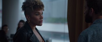 Movie still from “Blacklight” (2022), directed by Mark Williams – A woman in a leather jacket looking out of a window; Close Up shot, Low angle