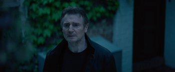 Movie still from “Blacklight” (2022), directed by Mark Williams – A person wearing a black jacket; Close Up shot, Over the shoulder angle