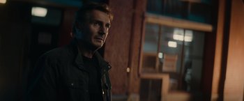 Movie still from “Blacklight” (2022), directed by Mark Williams – A person wearing a jacket; Close Up shot, Low angle