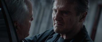 Movie still from “Blacklight” (2022), directed by Mark Williams – A man looking at another man in a black shirt; Close Up shot, Over the shoulder angle