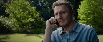 Movie still from “Blacklight” (2022), directed by Mark Williams – A person talking on a cell phone; Close Up shot, High angle