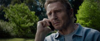 Movie still from “Blacklight” (2022), directed by Mark Williams – A person talking on a cell phone; Close Up shot, Low angle