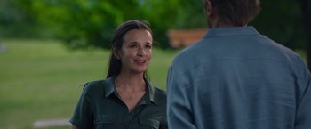 Movie still from “Blacklight” (2022), directed by Mark Williams – A woman standing next to a man in a field; Close Up shot, Over the shoulder angle