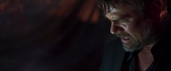 Movie still from “Blackout” (2022), directed by Sam Macaroni – A man's face in the dark; Close Up shot, Low angle
