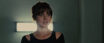 Movie still from “Blade Runner 2049” (2017), directed by Denis Villeneuve – A woman in a black shirt is looking at the camera; Close Up shot, Over the shoulder angle