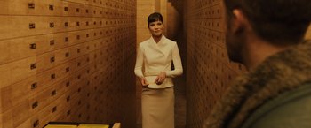Movie still from “Blade Runner 2049” (2017), directed by Denis Villeneuve – A woman in a long white dress holding a book; Medium shot, Low angle