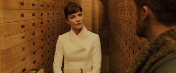 Movie still from “Blade Runner 2049” (2017), directed by Denis Villeneuve – A woman wearing a white dress standing in a hallway; Medium shot, Low angle
