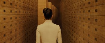 Movie still from “Blade Runner 2049” (2017), directed by Denis Villeneuve – A woman in a white suit is walking down a hallway; Medium shot, Low angle
