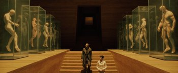 Movie still from “Blade Runner 2049” (2017), directed by Denis Villeneuve – A man and a woman standing on some steps; Wide shot, Low angle