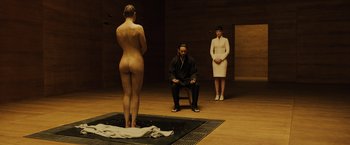 Movie still from “Blade Runner 2049” (2017), directed by Denis Villeneuve – A man and two women standing next to each other in a room; Wide shot, High angle