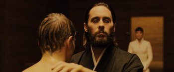 Movie still from “Blade Runner 2049” (2017), directed by Denis Villeneuve – A man with long hair and a beard looking into a mirror; Close Up shot, Over the shoulder angle