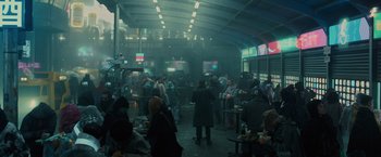Movie still from “Blade Runner 2049” (2017), directed by Denis Villeneuve – A group of people sitting at tables in a room; Extreme Wide shot, High angle