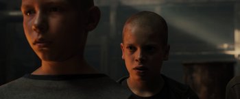 Movie still from “Blade Runner 2049” (2017), directed by Denis Villeneuve – A young man with a shaved head looking into a mirror; Close Up shot, Low angle