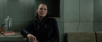 Movie still from “Blade Runner 2049” (2017), directed by Denis Villeneuve – A woman sitting in a room with a glass of water; Close Up shot, Low angle