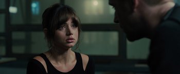 Movie still from “Blade Runner 2049” (2017), directed by Denis Villeneuve – A young woman looking at a man in a dark room; Close Up shot, Over the shoulder angle