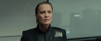 Movie still from “Blade Runner 2049” (2017), directed by Denis Villeneuve – A woman in a black jacket with a badge on her chest; Close Up shot, Low angle