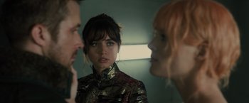 Movie still from “Blade Runner 2049” (2017), directed by Denis Villeneuve – A woman looking at two other people in a room; Close Up shot, Over the shoulder angle