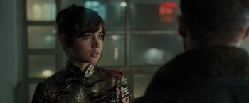 Movie still from “Blade Runner 2049” (2017), directed by Denis Villeneuve – A woman is sitting in front of a window at night; Close Up shot, Over the shoulder angle