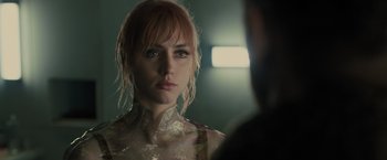 Movie still from “Blade Runner 2049” (2017), directed by Denis Villeneuve – A person wearing a dress and looking at the camera; Close Up shot, Over the shoulder angle