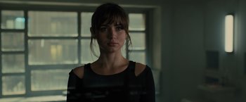 Movie still from “Blade Runner 2049” (2017), directed by Denis Villeneuve – A woman in a black shirt is looking at the camera; Close Up shot, Over the shoulder angle