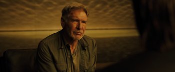 Movie still from “Blade Runner 2049” (2017), directed by Denis Villeneuve – An older man with a goatee is sitting in a room; Close Up shot, Over the shoulder angle