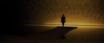 Movie still from “Blade Runner 2049” (2017), directed by Denis Villeneuve – A woman walking down a ramp in a dark room; Extreme Wide shot, Low angle